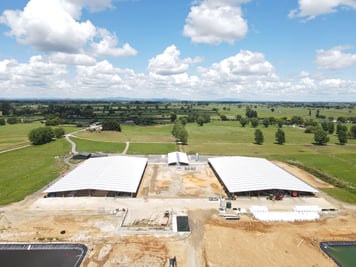 aerial view of two farm shed roofs and paddocks